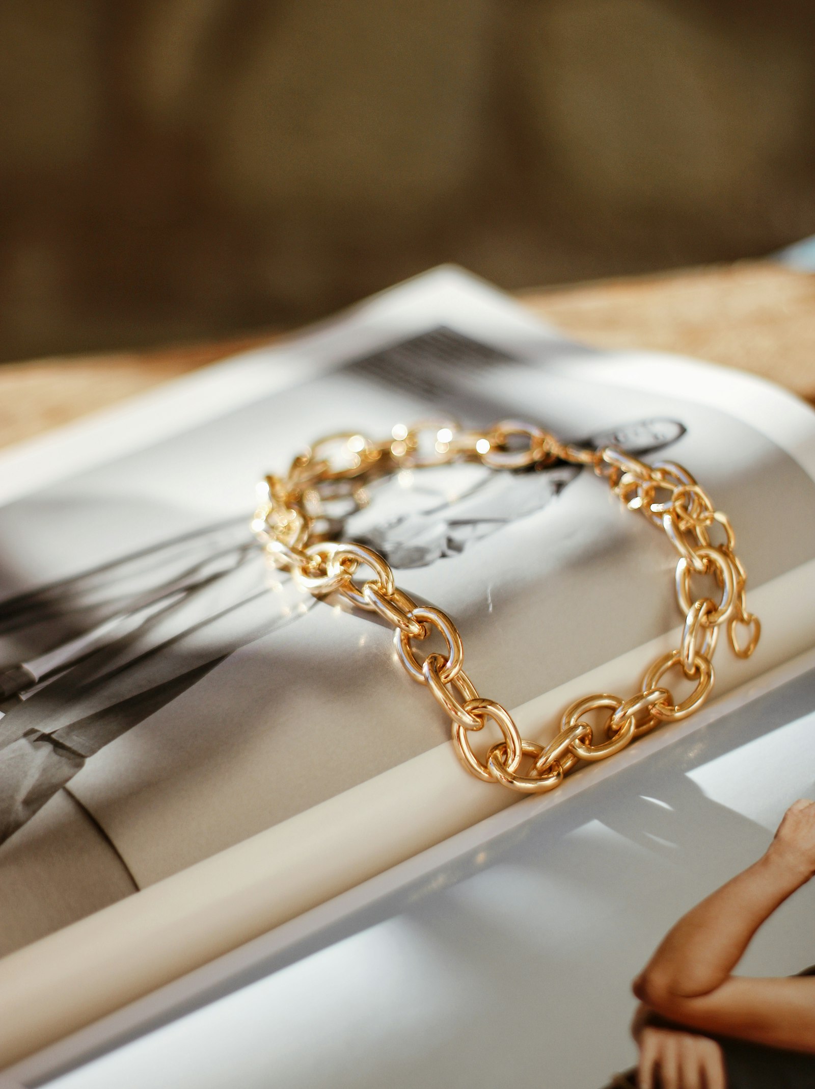 Chunky gold chain necklace resting on an open magazine